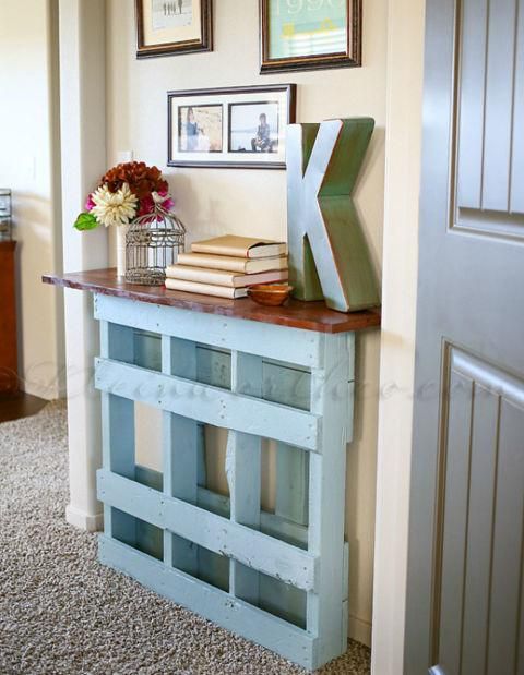 A vintage inspired blue console table of a pallet with a rich colored wooden tabletop is ideal for a sleek space