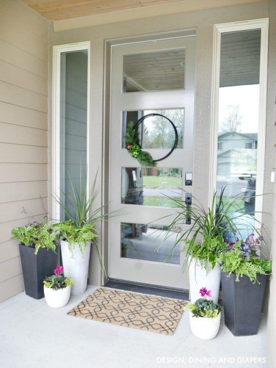 matching white and graphite grey planters with various greenery and flowers refresh and dress up the porch