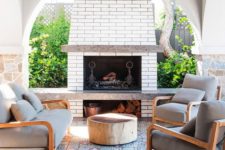 12 a bright outdoor lounge with a fireplace, a mosaic tile floor and a bold table plus comfy chairs