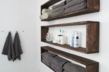 12 sleek and long wall-mounted bathroom shelves buuiltof dark sained pallet wood are ideal if you have little space