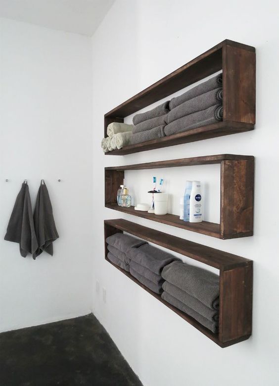 Sleek and long wall mounted bathroom shelves buuiltof dark sained pallet wood are ideal if you have little space