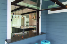 13 a garage-style dark framed window, a black tabletop and bright blue metal stools for cofy meals