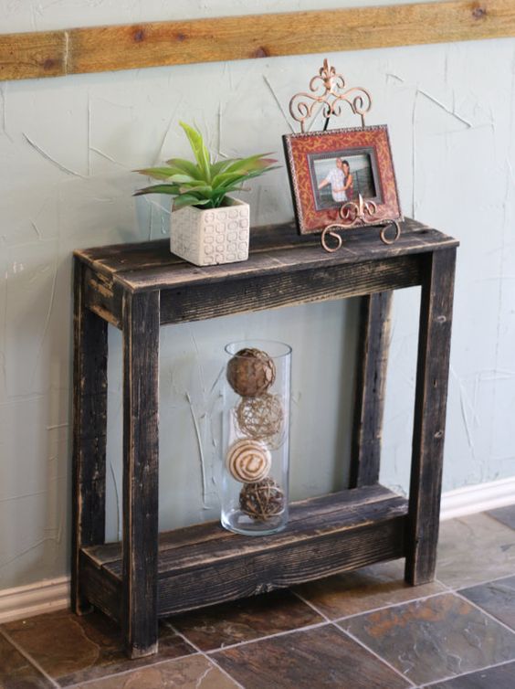 a shabby chic dark stained small console table will be a fit for a farmhouse or vintage entryway