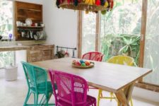 13 painted wicker chairs and a wicker lampshade decorated with faux fruit for a tropical dining space