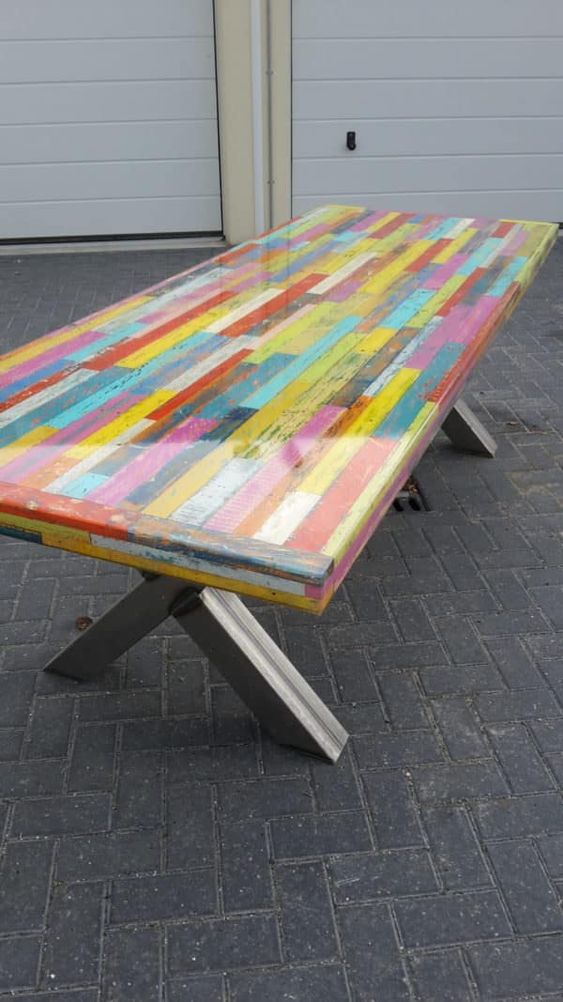 a colorful pallet dining table with a resin tabletop and comfy trestle legs is a unique idea