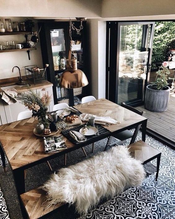 a gorgeous dining table with a chevron clad tabletop of pallet wood and black metal framing and matching benches for a boho space