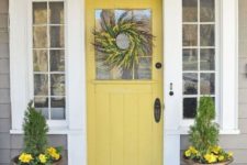 16 a mustard farmhouse door, antique stone urns with greenery and yellow blooms to match the door