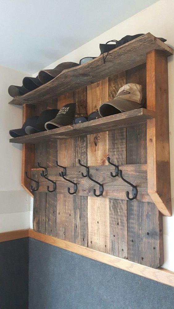 a stained wood pallet rack with space for caps and hats, with hooks is a great idea for an entryway