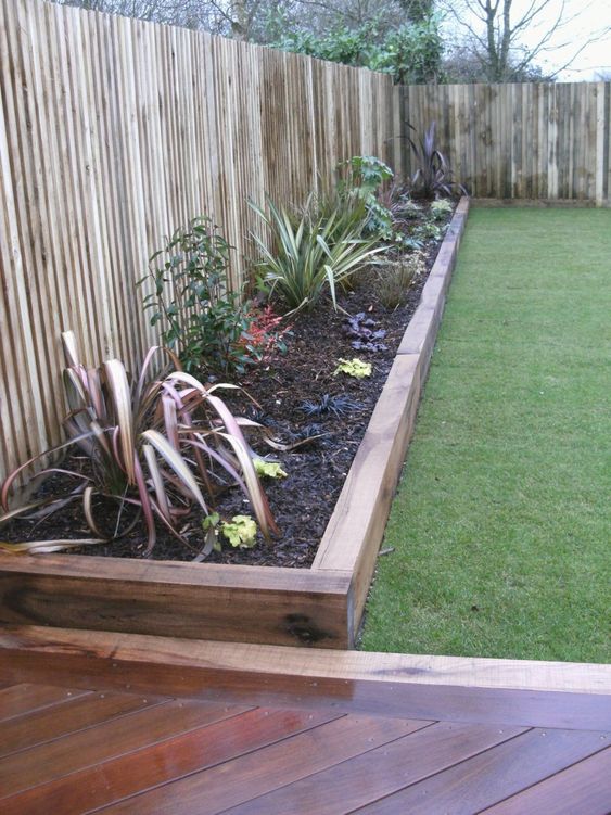 stained wood garden bed edging and matching pathways for a relaxed boho feel in your garden