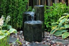 16 stylish black rock fountains with pebbles around will make your front yard more chic and bold