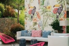 17 a colorful tropical patio with a white sofa and colorful pillows, hot pink chairs, a bright watercolor wall and little stools