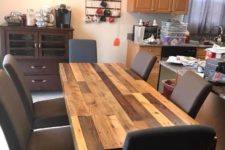17 a multi-colored rustic dining table built of pallet wood and upholstered chairs for a chic dining space