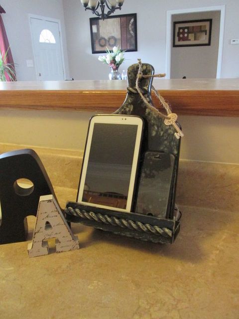 a small charging station for your phone made of a cutting board and a box stand is ideal for a kitchen
