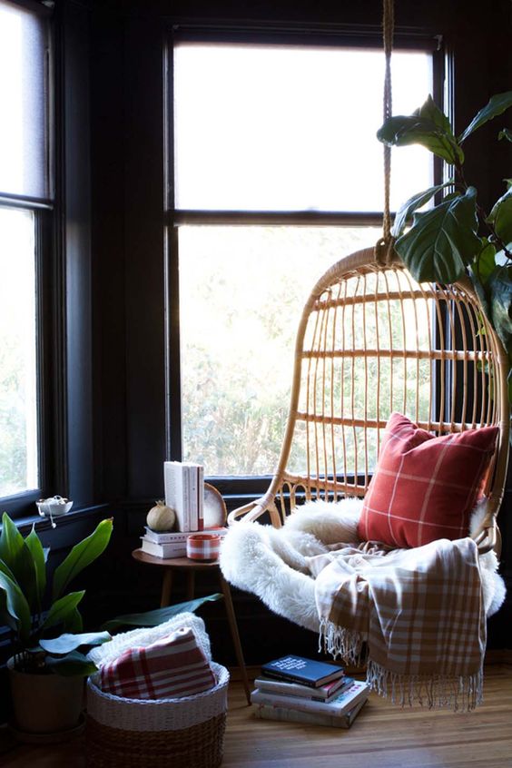 a hanging rattan birdcage chair with pillows, a blanket, a fur throw is a gorgeous base for a reading nook