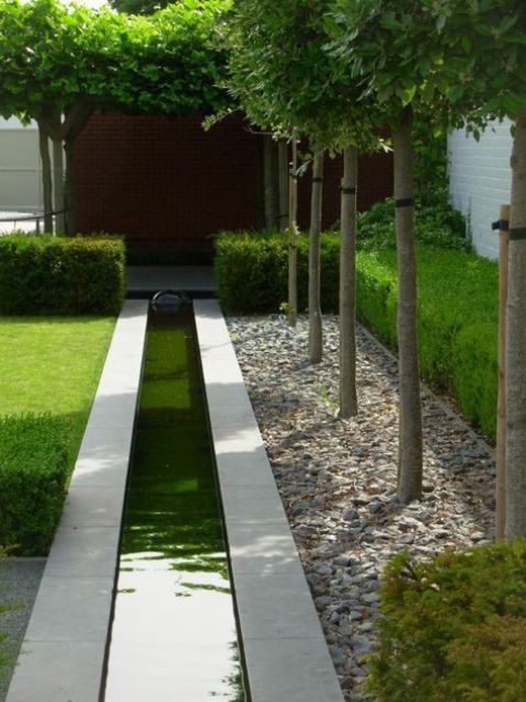 a long minimalist water feature with grey tiles lining it up looks very chic, bold and very simple at the same time