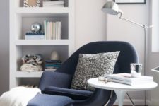 21 a navy chair and a footrest on tall metal legs inspired by mid-century modern designs