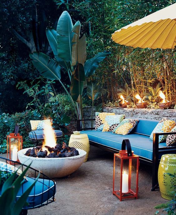 colorful pillows, red lanterns with candles, perforated tables and a large fire bowl to create an ambience