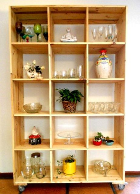A mobile storage unit build of pallet wood stained light is a cool unit for a kitchen or a dining space   here you'll see glasses and pots stored