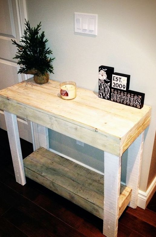 a simple rustic console table built of pallet wood painted white or stained in a light shade