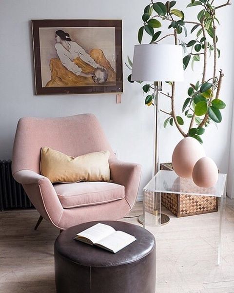  a blush mid-century modern chair with curves and angles is a cool piece, and a brown ottoman contrasts it