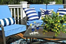 24 colorful pillows in blue and white for a nautical feel and star fish on the table plus a matching rug