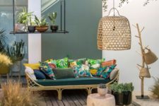 25 a welcoming tropical terrace with a rttan sofa, colorful pillows, a jute rug, wicker baskets and a wicker lampshade plus potted plants