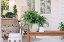 25 potted greenery, a small coffee table and a watering can for decorating a front porch