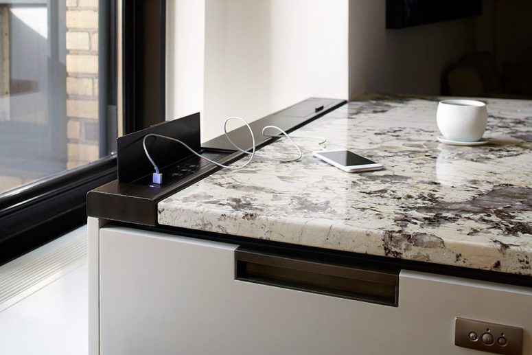 oxidized metal enclosure provides the charging ports in this uber-contemporary kitchen without compromising on design
