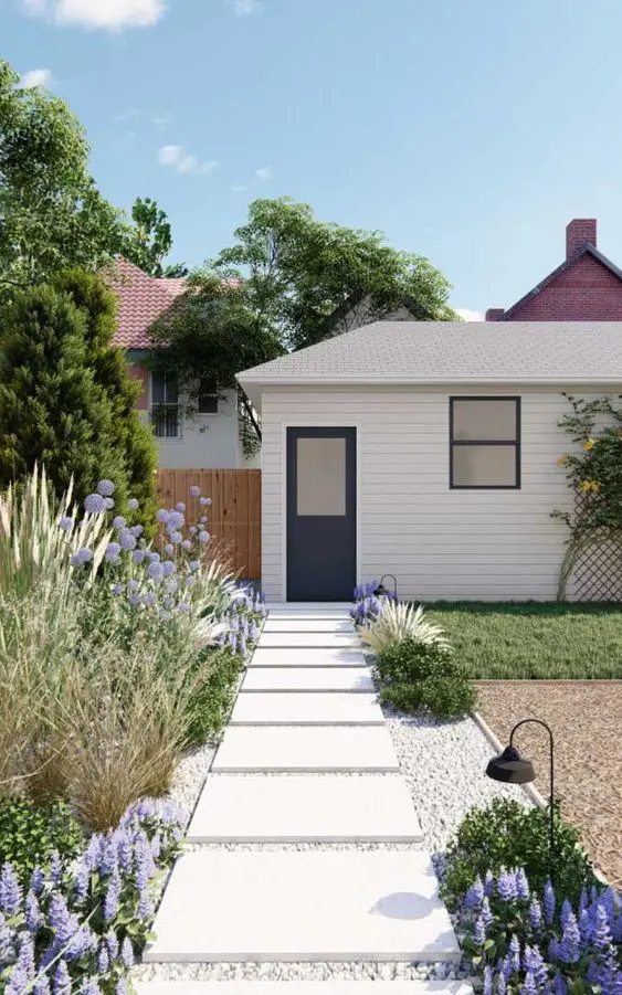 a beautiful front yard with a white stone path, lilac blooms, greeneyr and grasses is a drought tolerant space