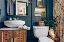 a catchy eclectic bathroom with black paneling, a cane vanity, a sink, a mirror wth lights and a floral print curtain