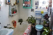 a crazily eclectic bathroom with white and black and white tiles, a tub, a sink, a toilet, some bold textiles, plants and decor