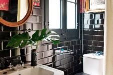 a maximalist bathroom with black subway tiles, red printed wallpaper, a round mirror, artworks and white appliances
