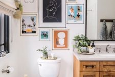 an eclectic bathroom with a stained vanity, a bright gallery wall, a basket with a neutral curtain on the wall