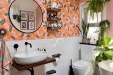 an eclectic bathroom with bold floral wallpaper, white subway tiles, white appliances, potted greenery and a shelf on the wall