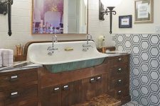 an eclectic bathroom with subway and hexagon tiles, a dark-stained vanity, a stool, a gallery wall and large sconces