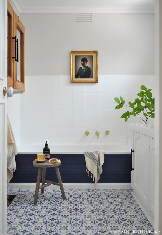 an eclectic space done in navy and white, with grey touches and natural wood plus potted greenery