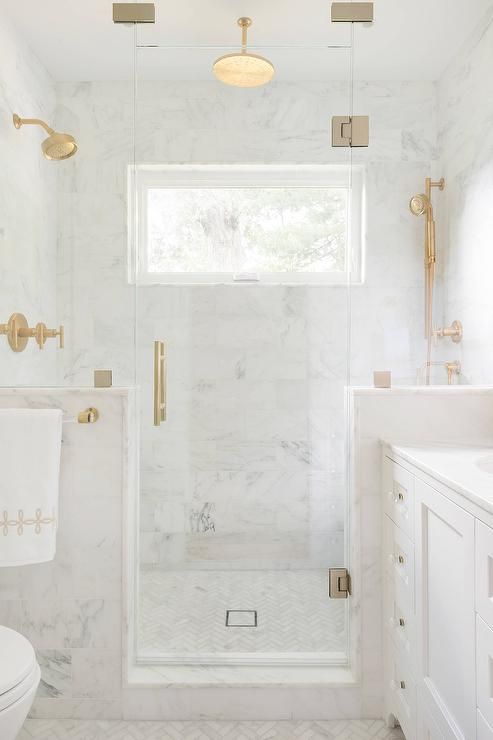 a white marble bathroom done with gold fixtures looks flawlessly elegant and very refined