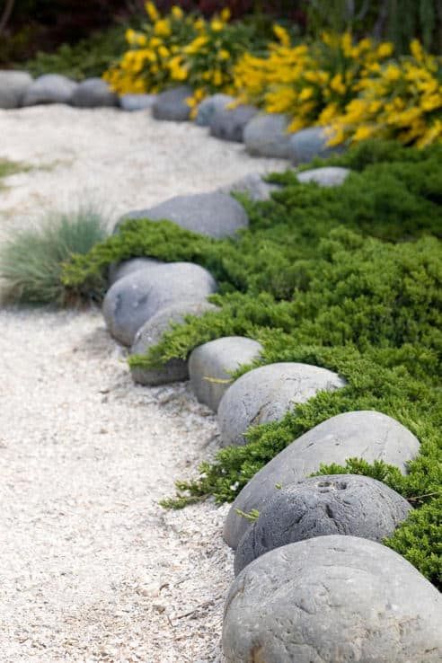 Oversized rocks and white garden pathways create an Asian feeling in the garden makign it all natural yet manicured