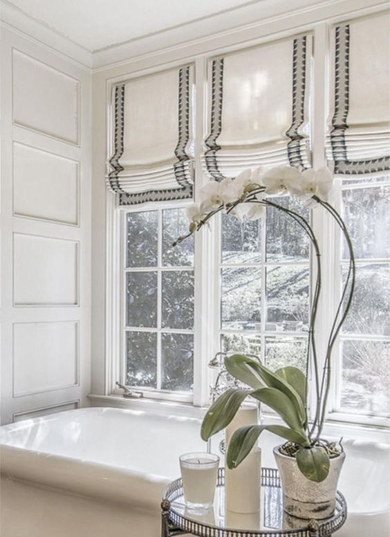 striped Roman shades are a chic idea for a modenr bathroom, they make it feel more welcoming and you can keep privacy any time