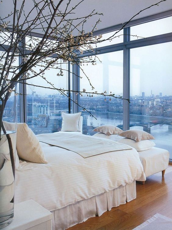 this bedroom with a view features totally no window treatments that allow enjoying the views anytime