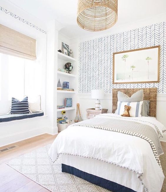 a kid's room accented with a statement wall with catchy printed wallpaper for a boho feel