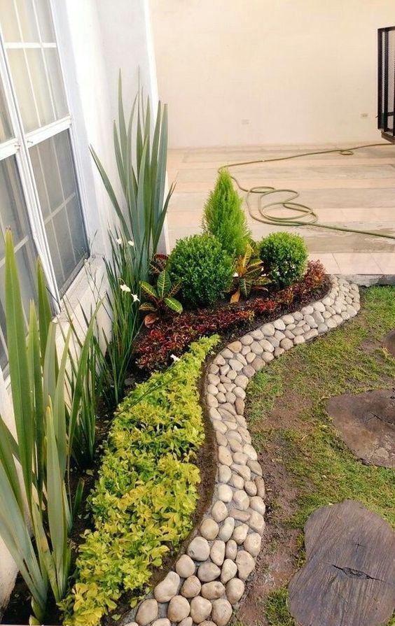 a stylish and creative pebble border is a cool way to add texture and interest to your raised garden bed