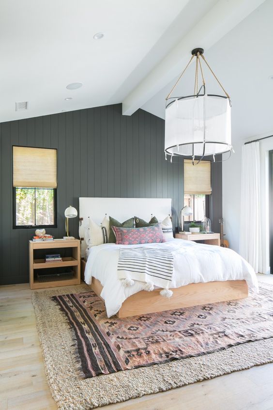 a chic farmhouse bedroom done with a black shiplap statement wall that adds drama and elegance to the space
