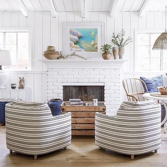 A coastal living room with a fireplace clad with white bricks that highlight this feature and add interest
