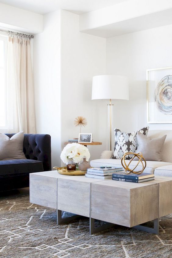 a contemporary living room with a white and navy sofa with a tall back plus a wooden coffee table