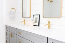 04 a grey double vanity, a white shiplap wall and gold fixtures, hardware and gold mirror frames