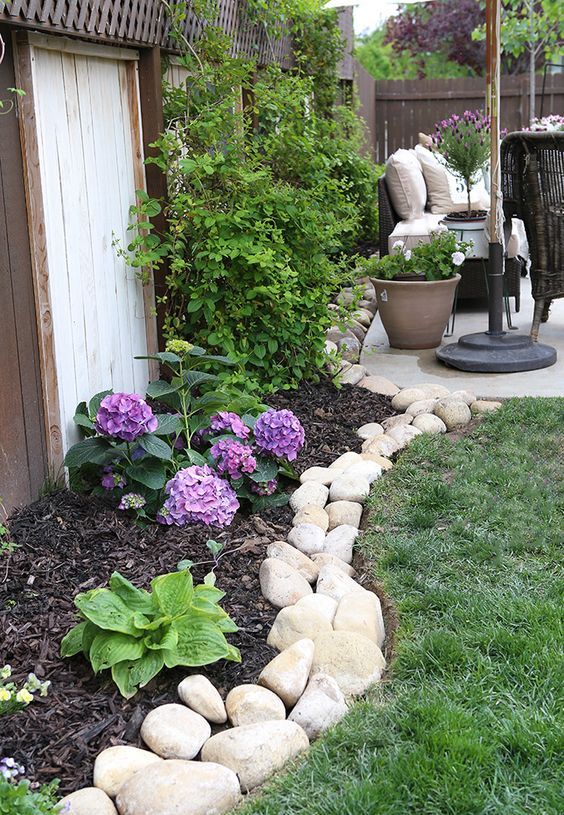 A river rock border brings a natural feel to the garden   the rocks show off different sizes and shapes