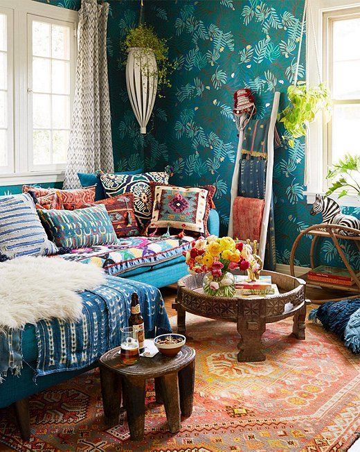 colorful and bright printed pillows and a blanket plus a rug and a faux fur piece make up the whole space