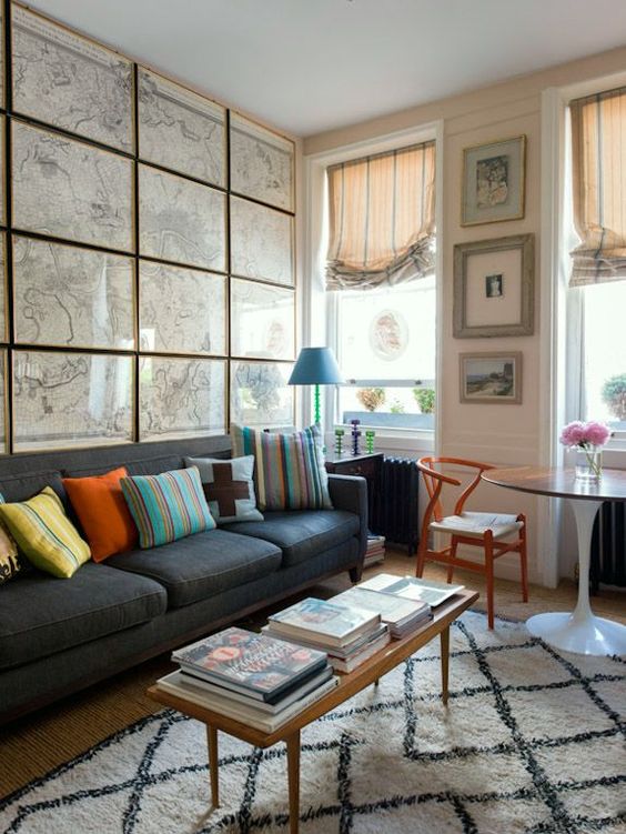 an eclectic living room  with a whole statement wall done with framed vintage maps all over