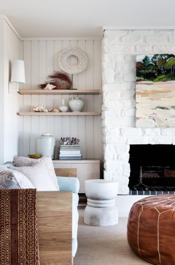 another white brick clad fireplace is the coziest and coolest decor feature in the coastal living room
